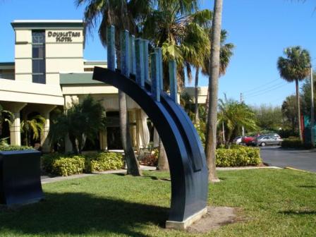 Abstract arc sculpture on side of road near hotel