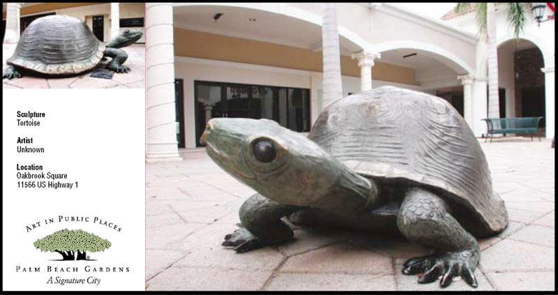Statue of tortoise in open, brick-paved area